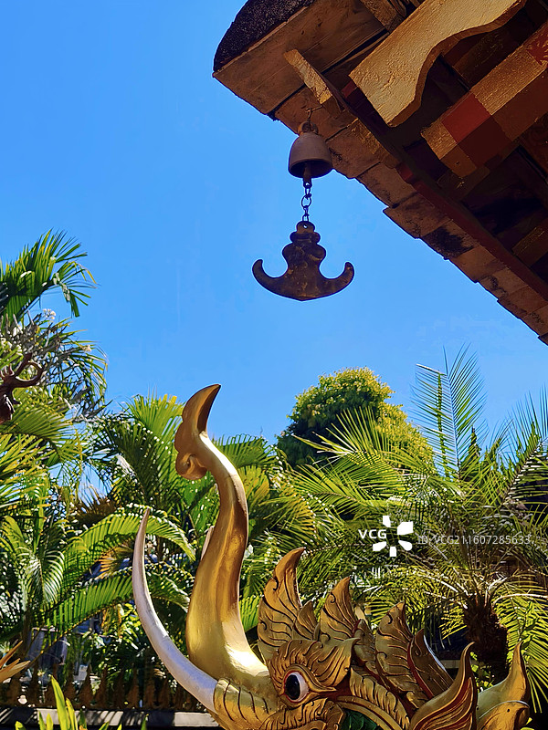 在澄澈蓝天与葱郁绿意的映衬下，古建檐角的铜铃和鎏金神兽一同浸在明媚的日光里。图片素材