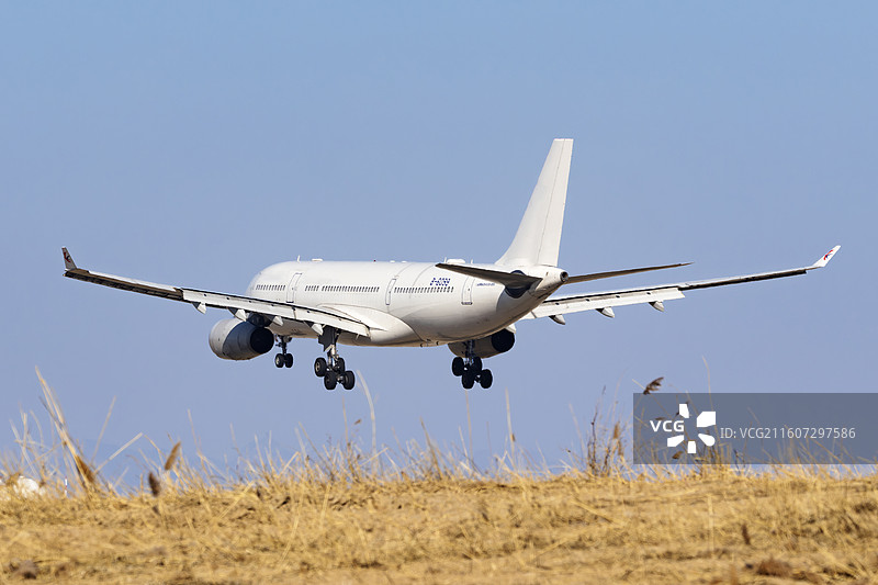 落向土坡背后的东方航空A330图片素材