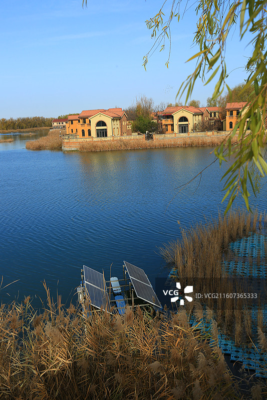 碧水环萦鹭岛明，晨曦鸟语共欢声 楼台倒影浮波翠，冬泉暖雾绕堤轻 明珠璀璨白洋淀，雄安巍峨巨湖横图片素材