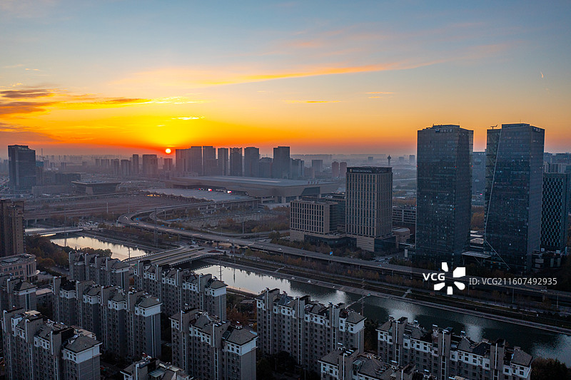 河南郑州七里河城市沿岸日出风光、郑州东站城市天际线图片素材