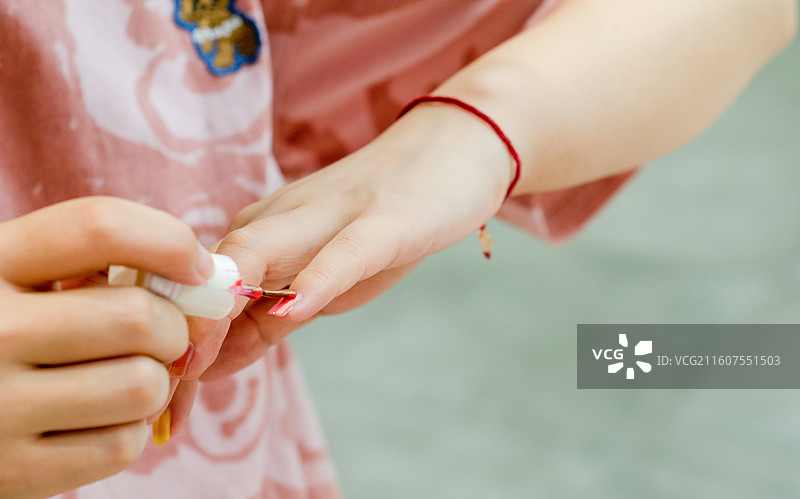 正在往手上涂抹指甲油图片素材