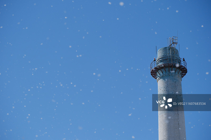 人间四月天。漫天飞舞的杨絮。春天蓝色天空背景下的老式水塔图片素材