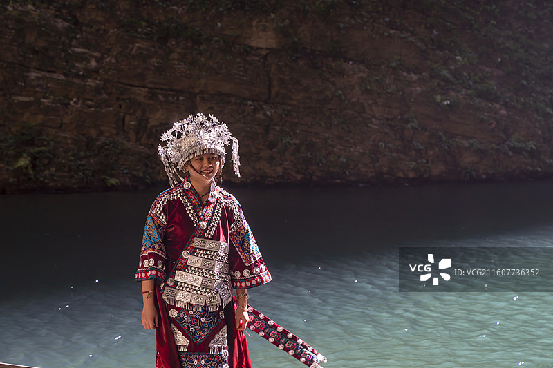 一位土家族苗族美女在波光粼粼水面上游玩，中国鹤峰屏山峡谷图片素材