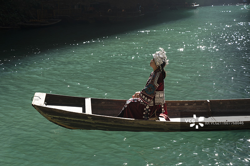 一位土家族苗族美女在波光粼粼水面上游玩，中国鹤峰屏山峡谷图片素材