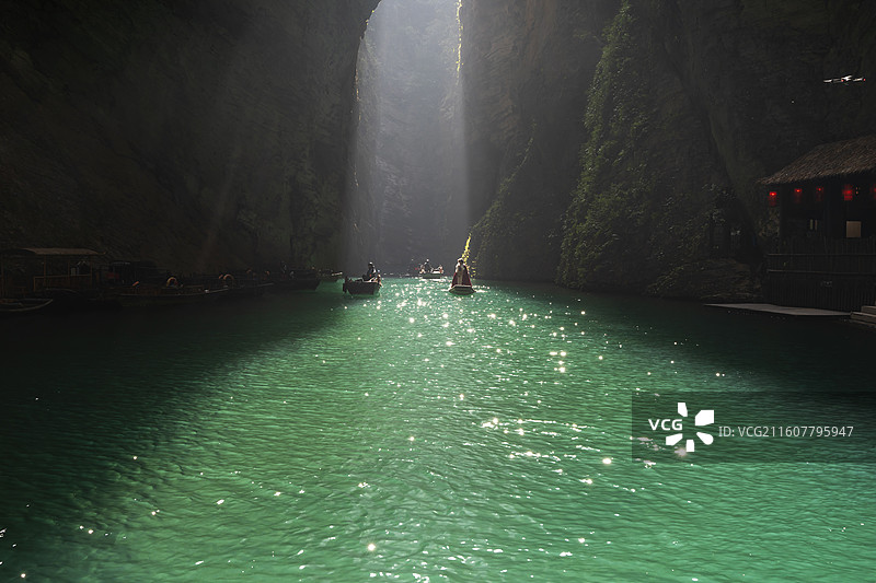 一位穿红色斗篷的古风服饰美女乘一叶扁舟游玩中国鹤峰屏山峡谷图片素材