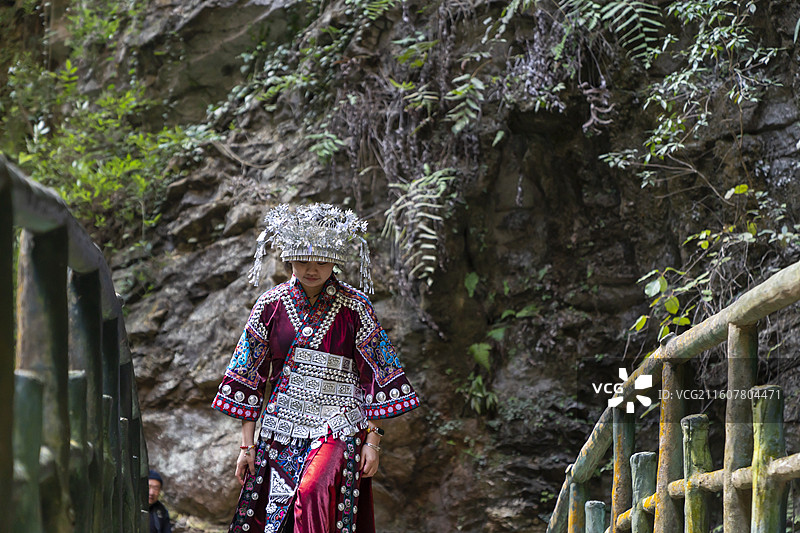 一位土家族苗族姑娘在桥上游玩，中国鹤峰屏山峡谷图片素材