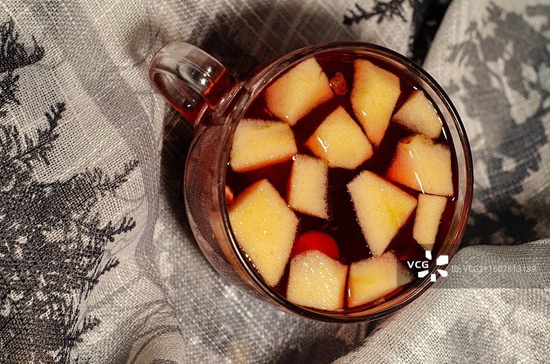 含苹果块饮品置于特色布上的静物特写图片素材