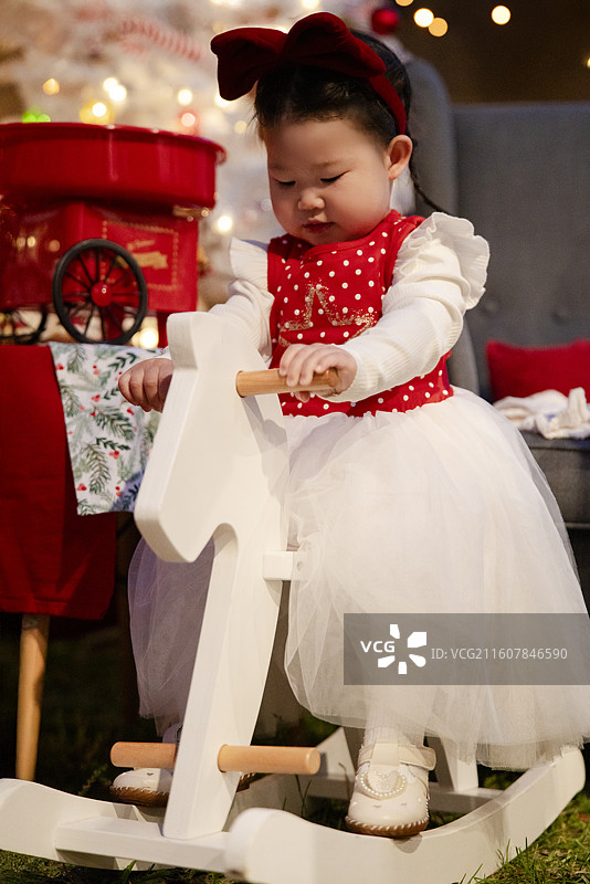 圣诞之夜骑白木马的小女孩图片素材