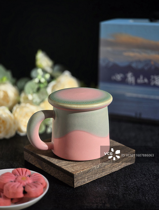 静物桌上带盖粉绿色马克杯视图图片素材