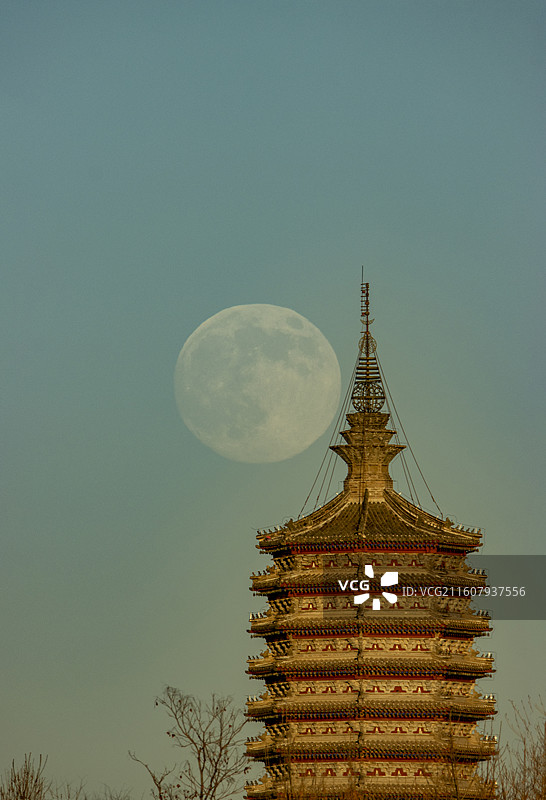 超级月亮和北京通州燃灯塔同框，落日余晖映照在千年古塔上图片素材