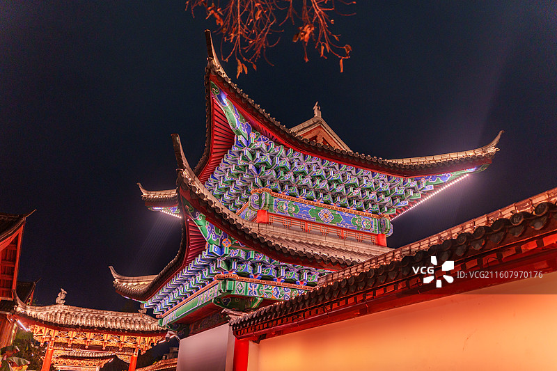 云南省丽江古城内丽江木府内飞檐彩绘的极致特写，宝蓝翠绿的繁复斗拱彩绘、朱红飞檐与墨黑夜空完美融合图片素材