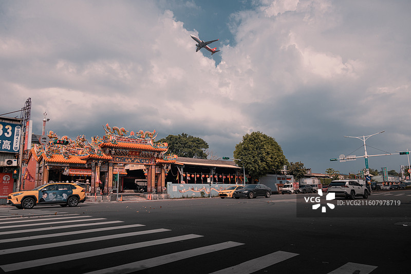 城市街道上的飞机-航空飞机越城市庙宇街口的都市文化街景图片素材