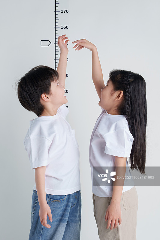 两个孩子测量身高图片素材