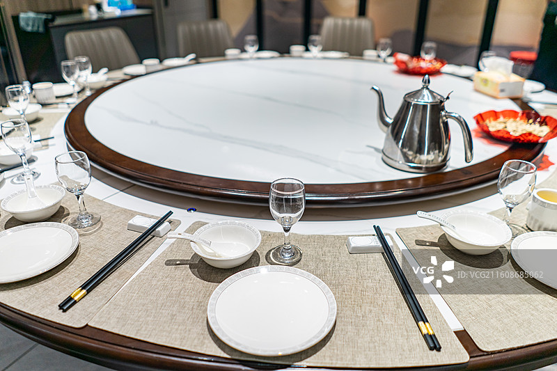 中国餐饮行业，空的餐桌拍摄主题，中国传统木制圆桌上的透明玻璃和餐具，室内无人图像摄影图片素材
