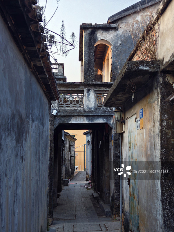 《古巷残梦》 斑驳巷弄间，老墙的裂痕里嵌着旧时光的碎片，廊桥的雕栏在暮色中若隐若现。图片素材