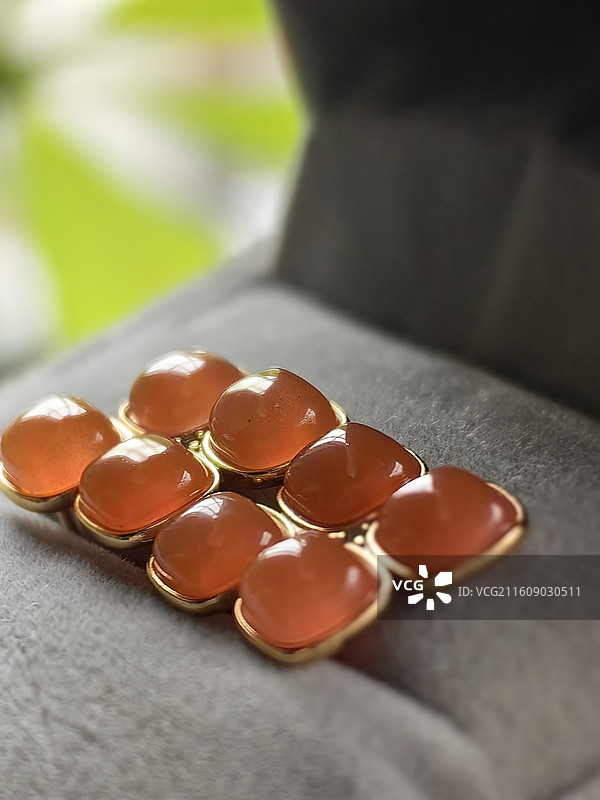 “把南红的暖橘色，镶进金框里。自然光下的通透感，像把冬日的蜜意都锁进了首饰盒。图片素材