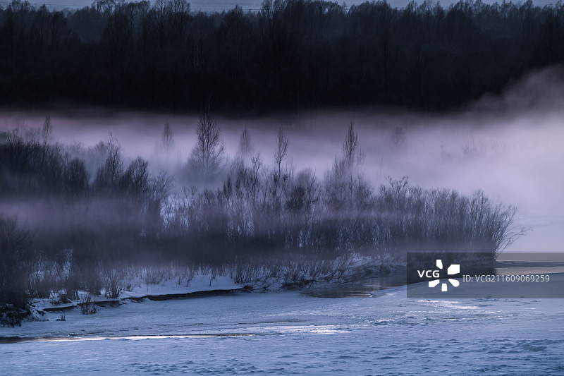 冬天大兴安岭加格达奇甘河霞光，日落后尚未冰封的河面水汽升腾，雾气弥漫在河道沙洲红柳丛中，形成暮霭图片素材