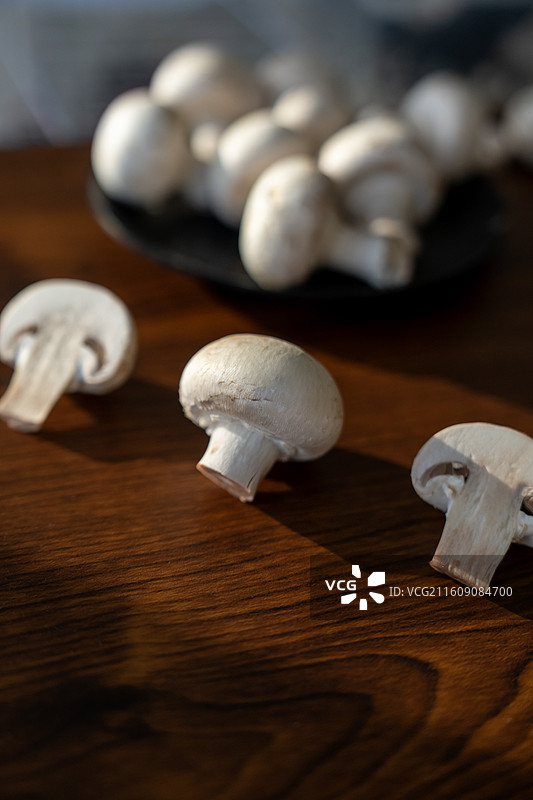 桌面上排列整齐的口蘑，暗色背景图片素材