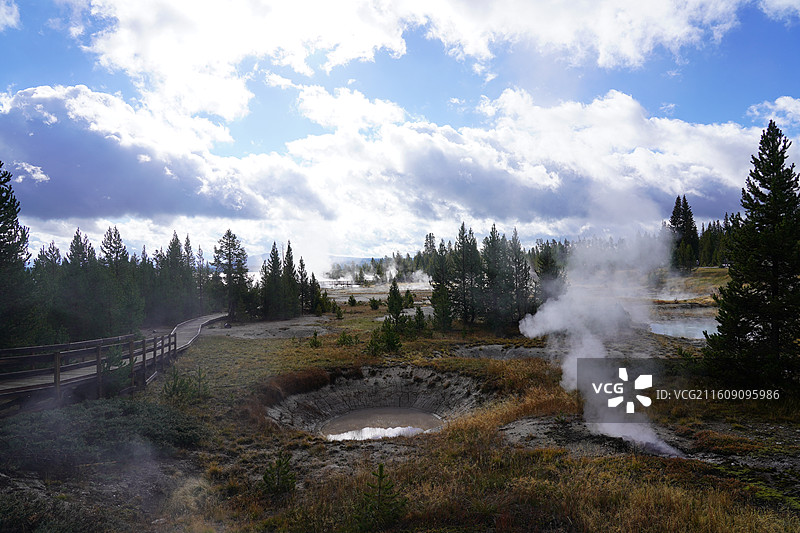 美国黄石公园的秋日美景 加拿大鹅成群结队飞过彩叶林和湖泊 雪山在远方 涌出滚烫泉水的五彩池和日光狂热图片素材