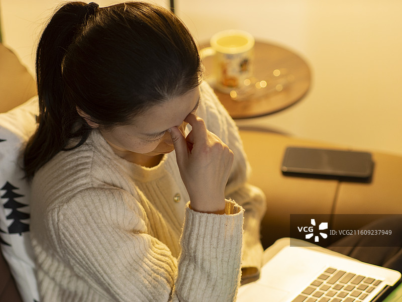 中国女性居家办公压力大头疼吃药图片素材