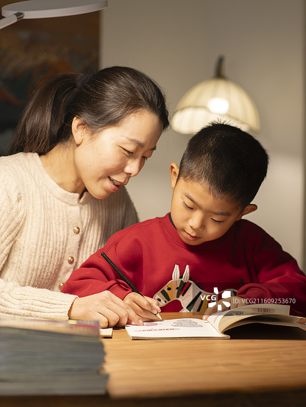 中国母亲夜晚辅导小朋友作业图片素材