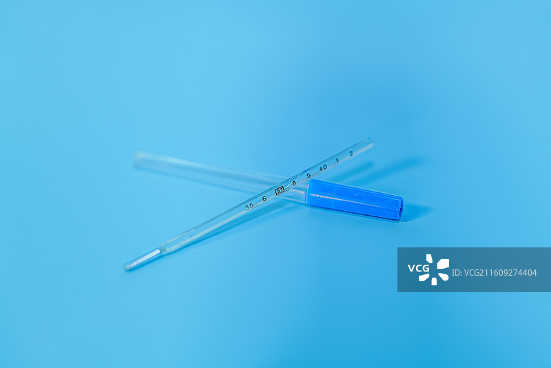 蓝色背景上的医疗设备水银温度计d特写镜头图片素材