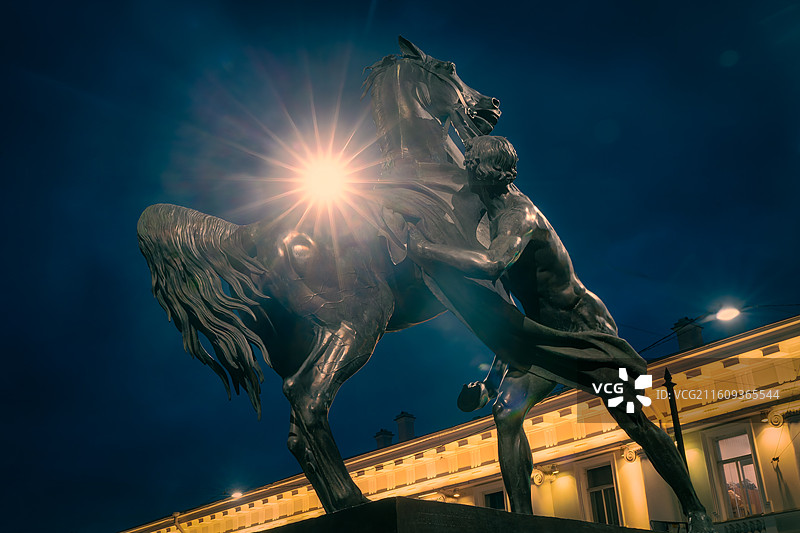 俄罗斯圣彼得堡阿尼奇科夫桥夜色：驯马师雕像与璀璨星芒图片素材