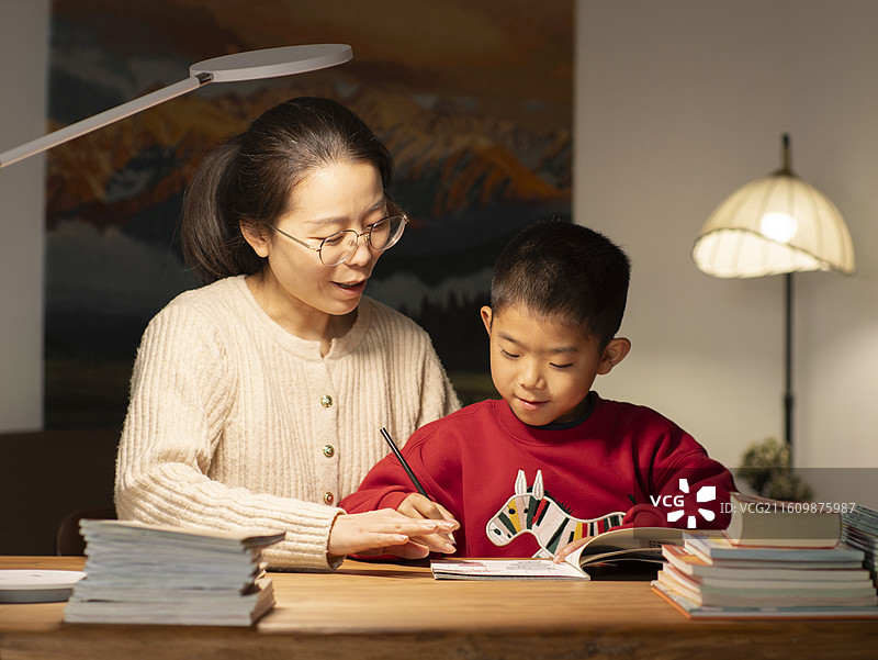 中国母亲夜晚辅导小朋友作业图片素材
