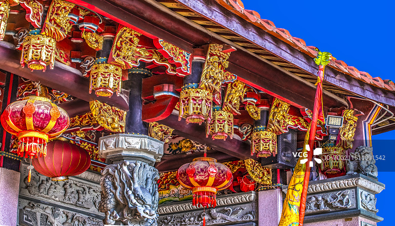 蓝天下福建泉州浔埔顺济宫妈祖宫一进左侧精美绝伦木质柱梁栋垂柱斗拱雕刻彩绘鎏金侧视特写图图片素材