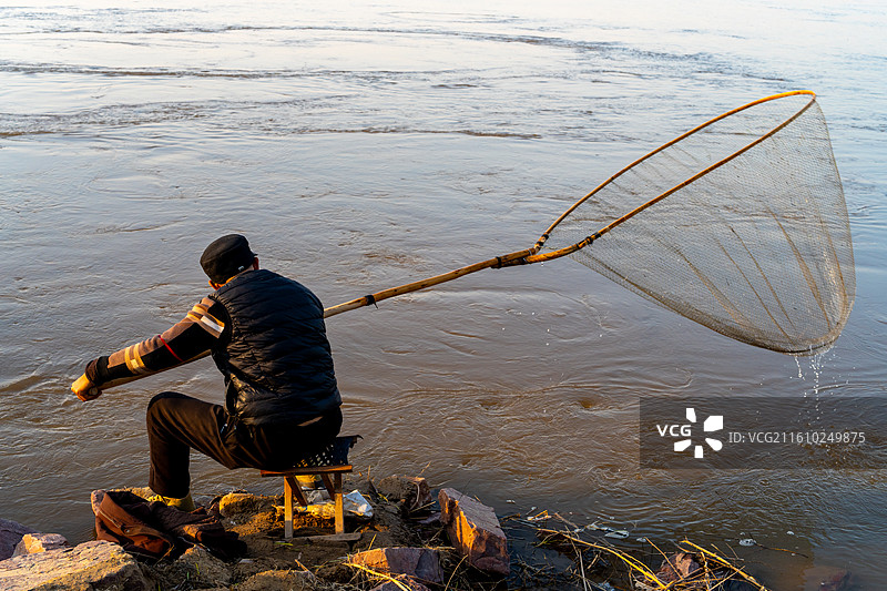 冬日黄河岸边老人捕鱼生活方式图片素材