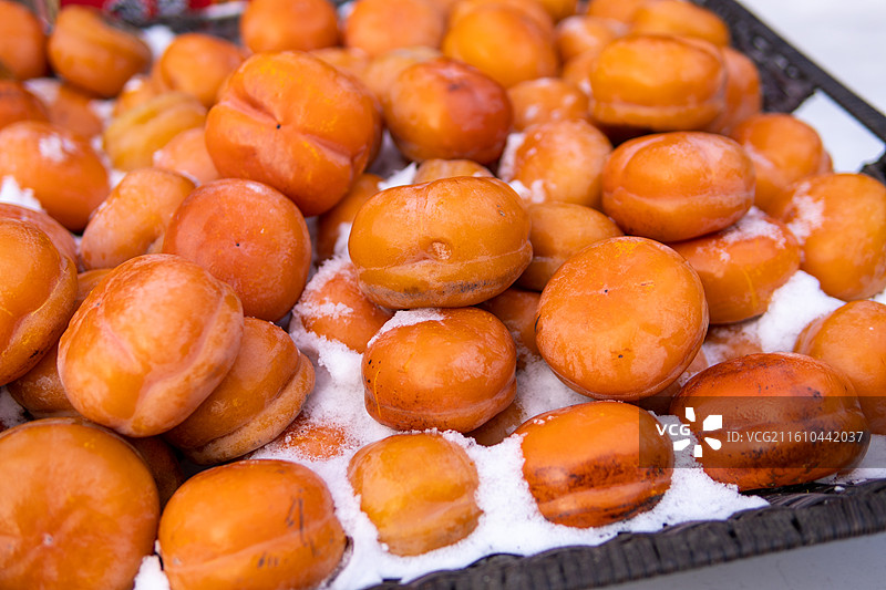 铺在雪上的冻柿子图片素材