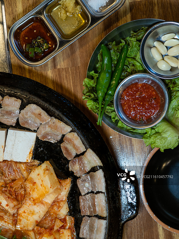 韩国餐厅里传统的釜盖烤五花肉配泡菜和豆腐图片素材
