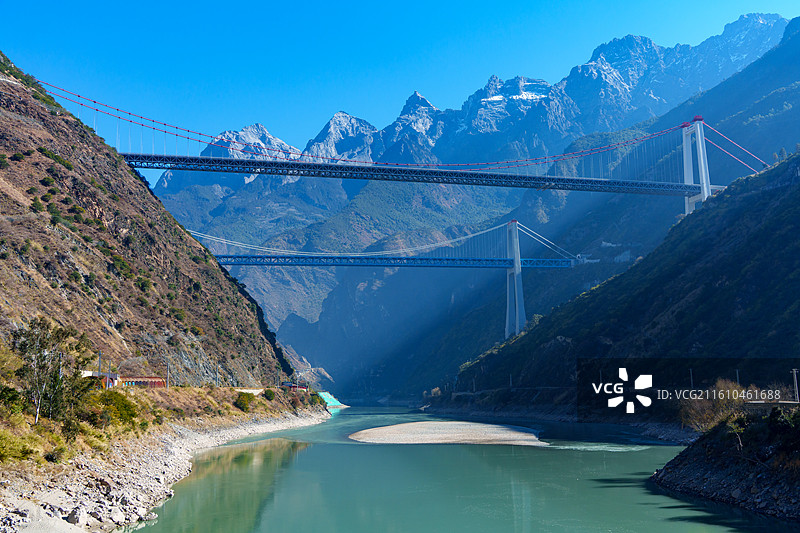 云南省丽江香格里拉虎跳峡附近金沙江峡谷段丽香高速和丽香铁路大桥组成“双桥跨峡、雪山为幕”的广角全景图片素材