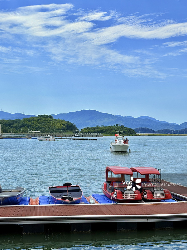 蓝天白云下的天妃湖和码头的游船图片素材