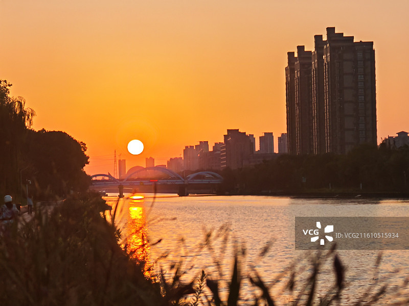 夕阳下的天空映衬下的河流景观图片素材