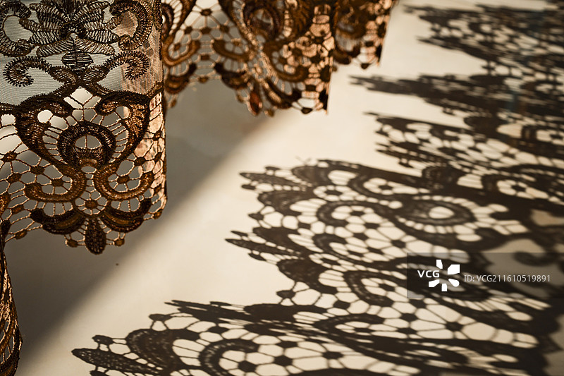 温暖阳光照在落地窗窗帘和地面上的花纹图案影子图片素材