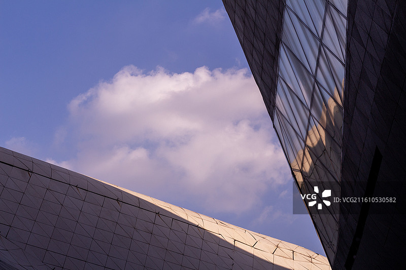 紫色天空背景下的广州大剧院玻璃幕墙上城市摩天大楼建筑反射风光图片素材