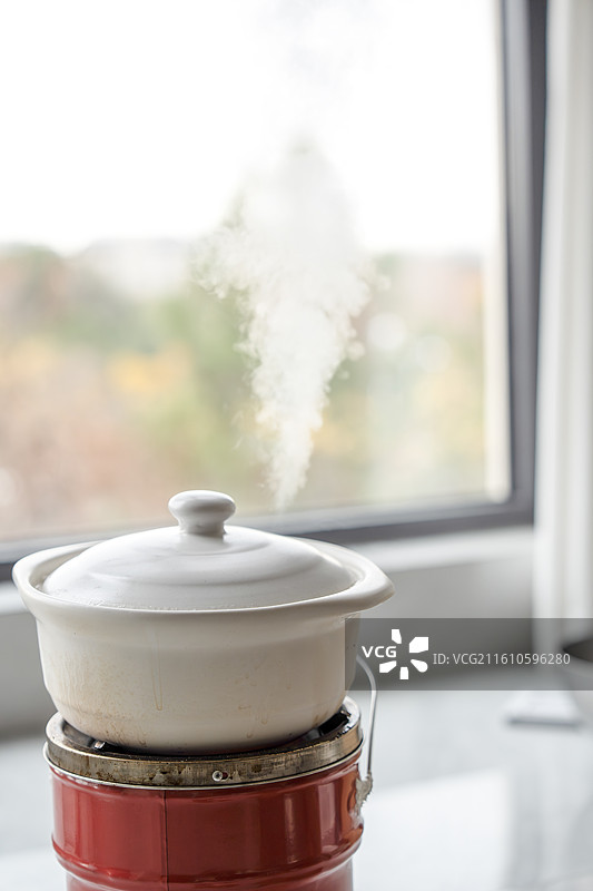 冬日室内正在加热的砂锅与冒出的蒸汽图片素材