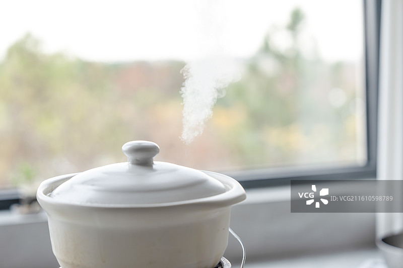 冬日室内正在加热的砂锅与冒出的蒸汽图片素材