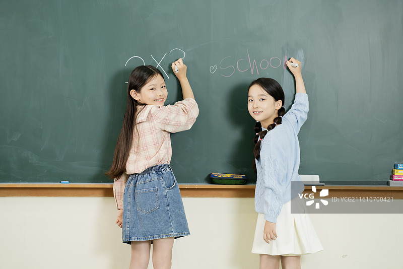 女学生在黑板上写字图片素材