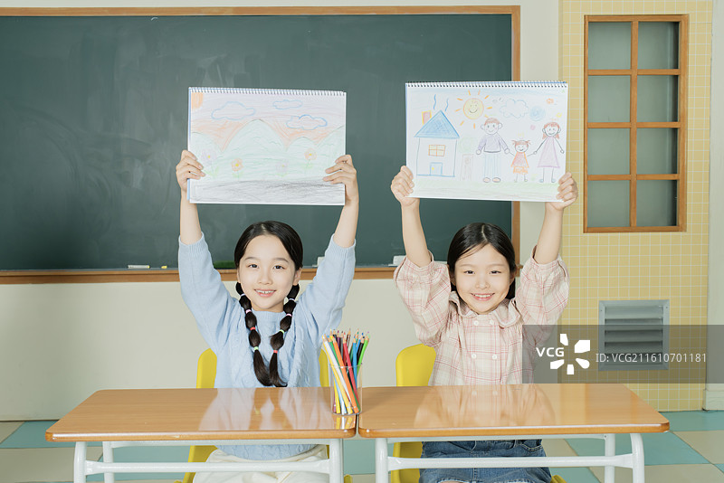 女学生在美术课上展示她们的画作图片素材