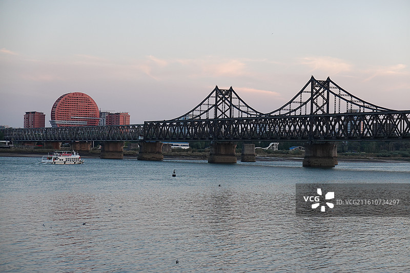 辽宁省丹东市振兴区鸭绿江断桥中朝友谊桥：远眺朝鲜新义州太阳楼晚霞夕阳图片素材