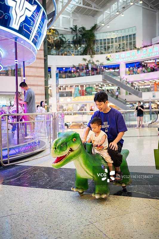 和爸爸在广州正佳广场开恐龙车的小男孩图片素材