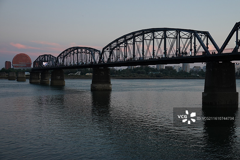 辽宁省丹东市振兴区鸭绿江断桥：远眺朝鲜新义州太阳楼晚霞图片素材