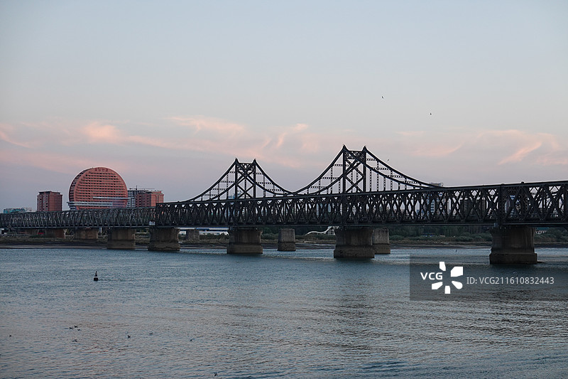 辽宁省丹东市振兴区鸭绿江断桥中朝友谊桥：远眺朝鲜新义州太阳楼晚霞夕阳图片素材