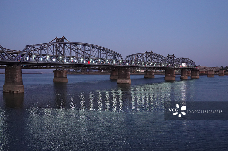 辽宁省丹东市振兴区鸭绿江断桥和中朝友谊桥：傍晚蓝调暮光图片素材