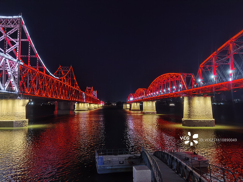 辽宁省丹东市振兴区鸭绿江断桥和中朝友谊桥夜景灯光秀图片素材