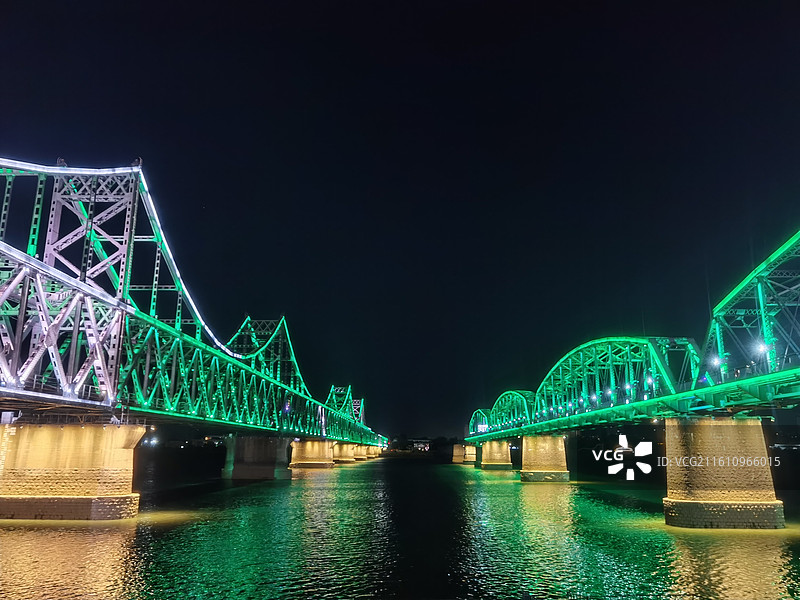 辽宁省丹东市振兴区鸭绿江断桥和中朝友谊桥夜景灯光秀图片素材