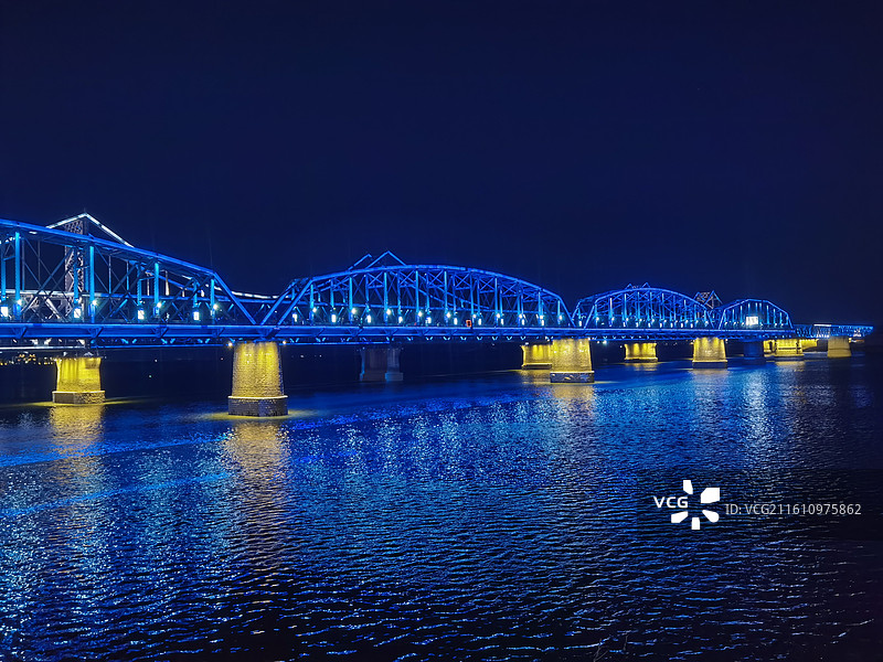 辽宁省丹东市振兴区鸭绿江断桥和中朝友谊桥夜景灯光秀图片素材