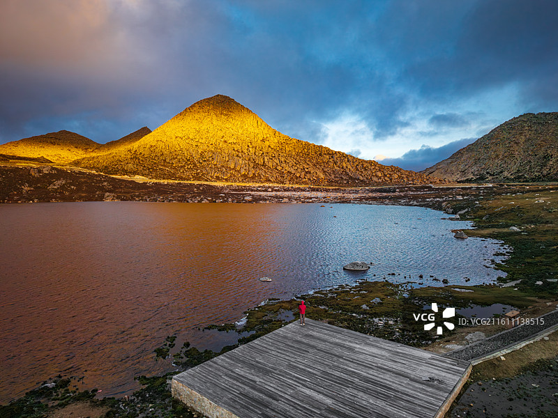 红衣摄影师记录第一缕阳光点亮理塘铁匠山景点图片素材